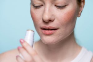 ragazza che mette un prodotto cosmetico sul volto
